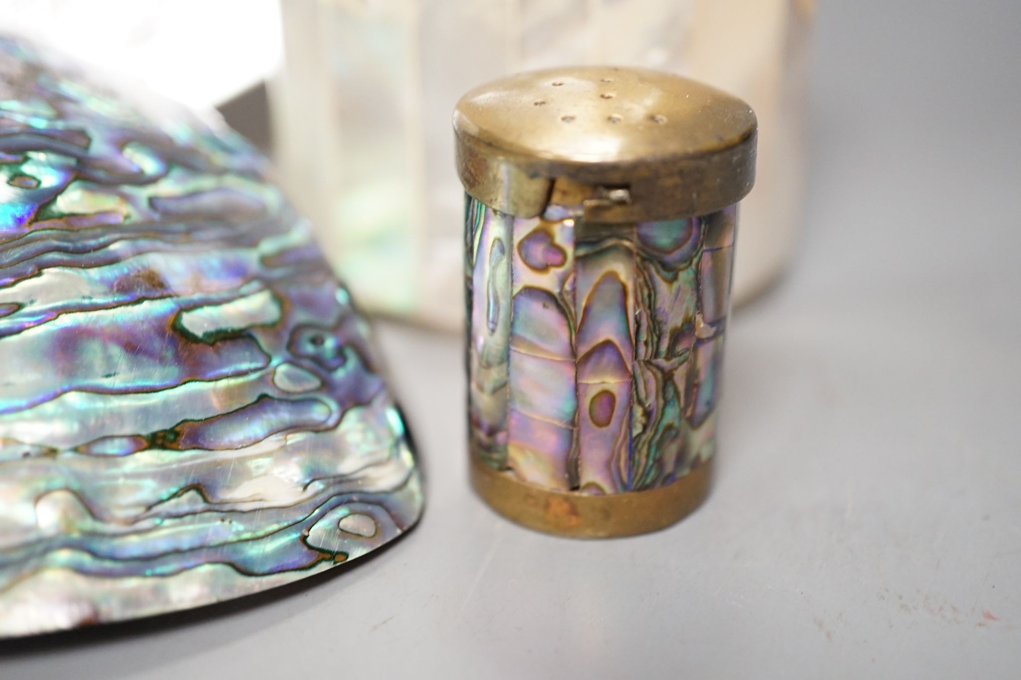 An engraved pearl shell, 22cm, a cylindrical box and bracelet, and two abalone shells